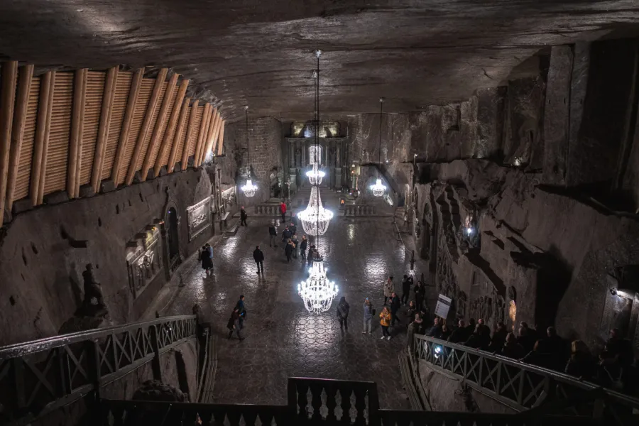 View from a balcony into the vast, underground St. Kinga's Chapel in the Wieliczka Salt Mine, lit by salt chandeliers.