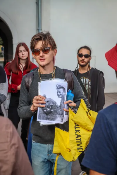 Ein Reiseführer zeigt einer Gruppe während einer Tour in Krakau ein historisches Foto eines polnischen Soldaten mit Wojtek...