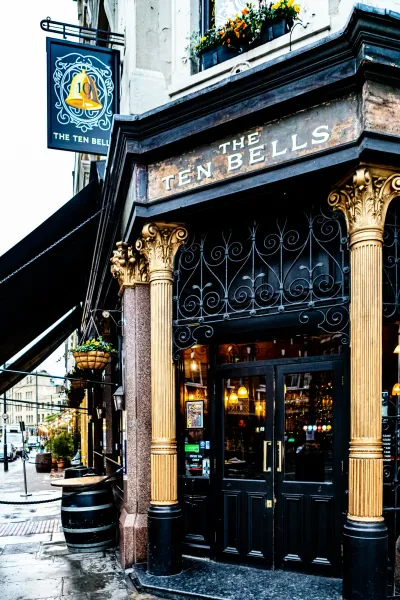 Entrada ornamentada en negro y dorado del pub The Ten Bells en Londres - letrero tradicional sobre la puerta.