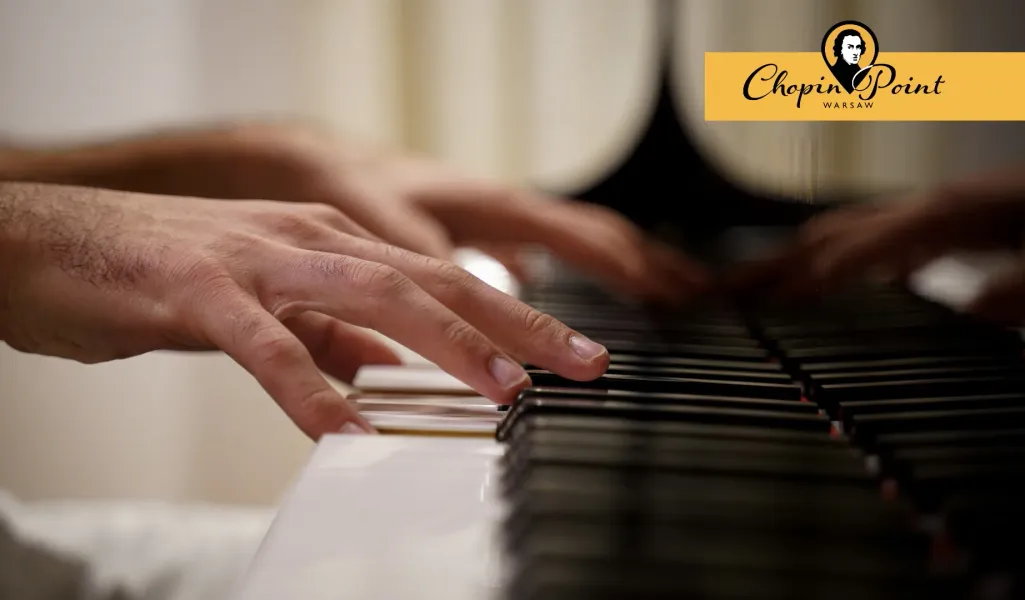 Close-up of a person's hands playing black and white piano keys during a performance.