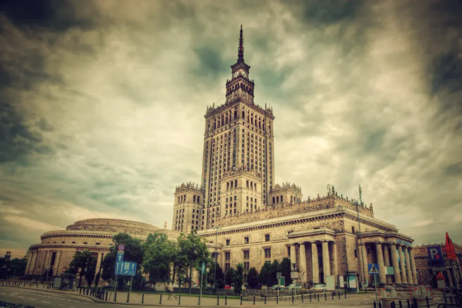El Palacio de la Cultura y la Ciencia en Varsovia, un edificio alto y ornamentado con una aguja, se erige bajo un cielo nu...