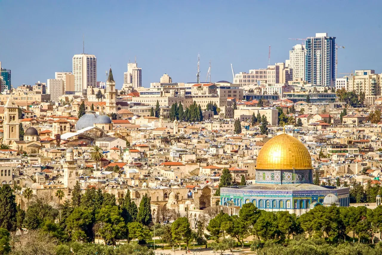 Blick auf Jerusalem mit dem goldenen Felsendom im Vordergrund und den Gebäuden der Altstadt und modernen Hochhäusern im Hinte