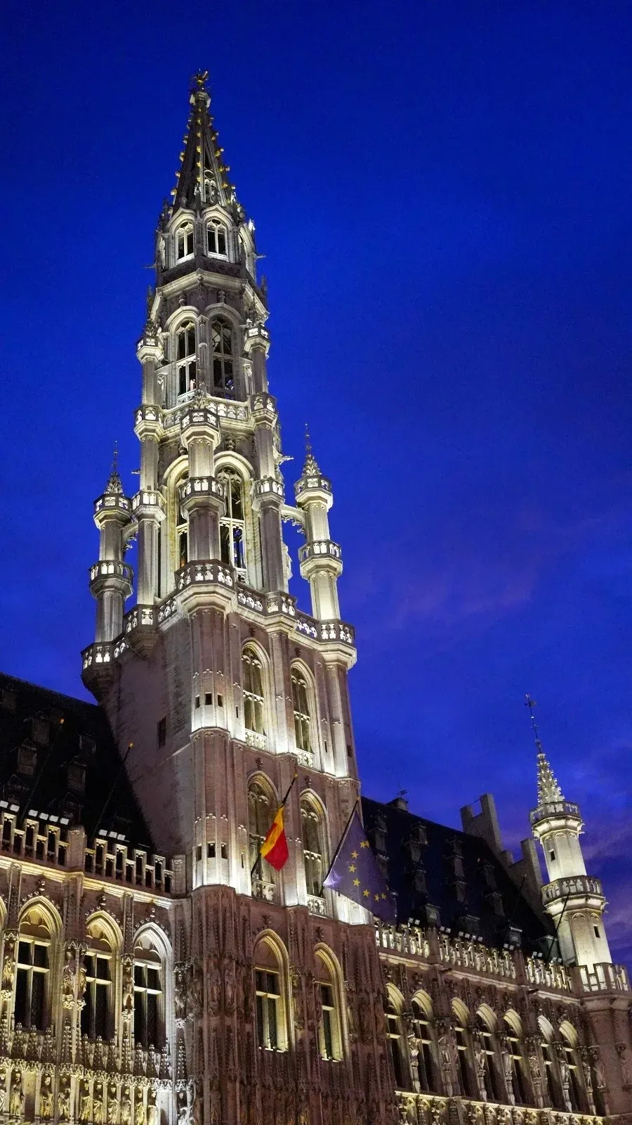 El Ayuntamiento de Bruselas por la noche, iluminado contra el cielo oscuro.