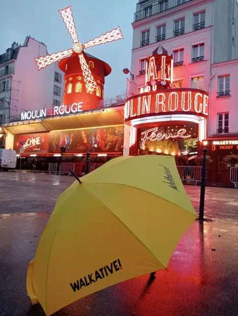 Walkative! tour guide umbrella in front of the Moulin Rouge in Paris.