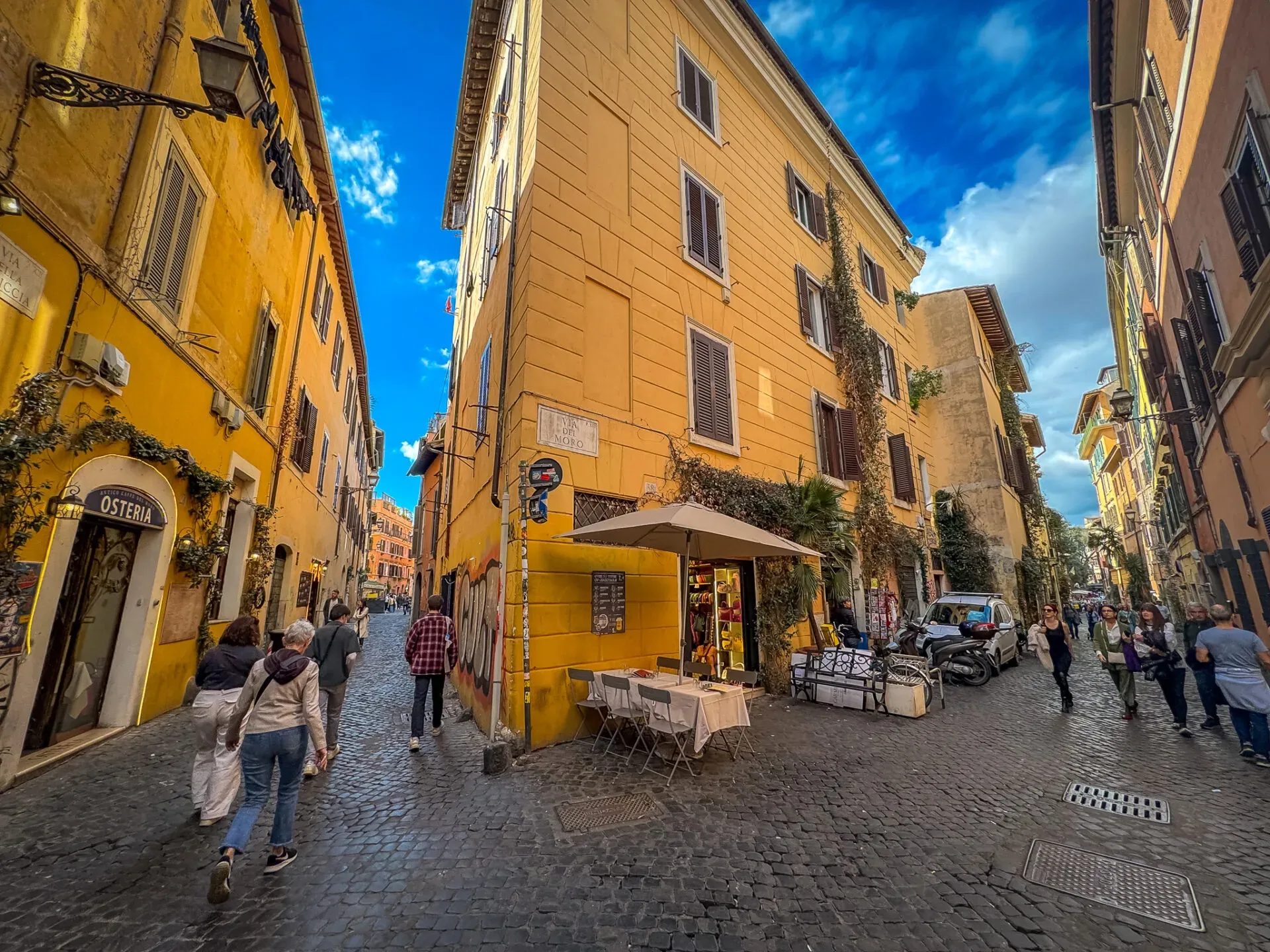 Turistas explorando las encantadoras calles empedradas de Trastevere, Roma.