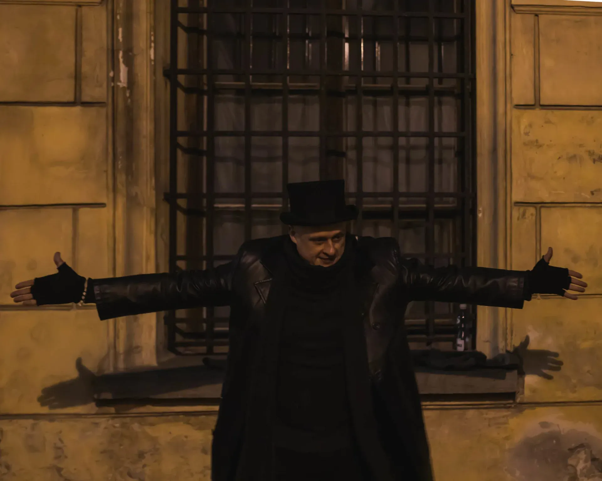 Przewodnik w cylindrze przed starym budynkiem.