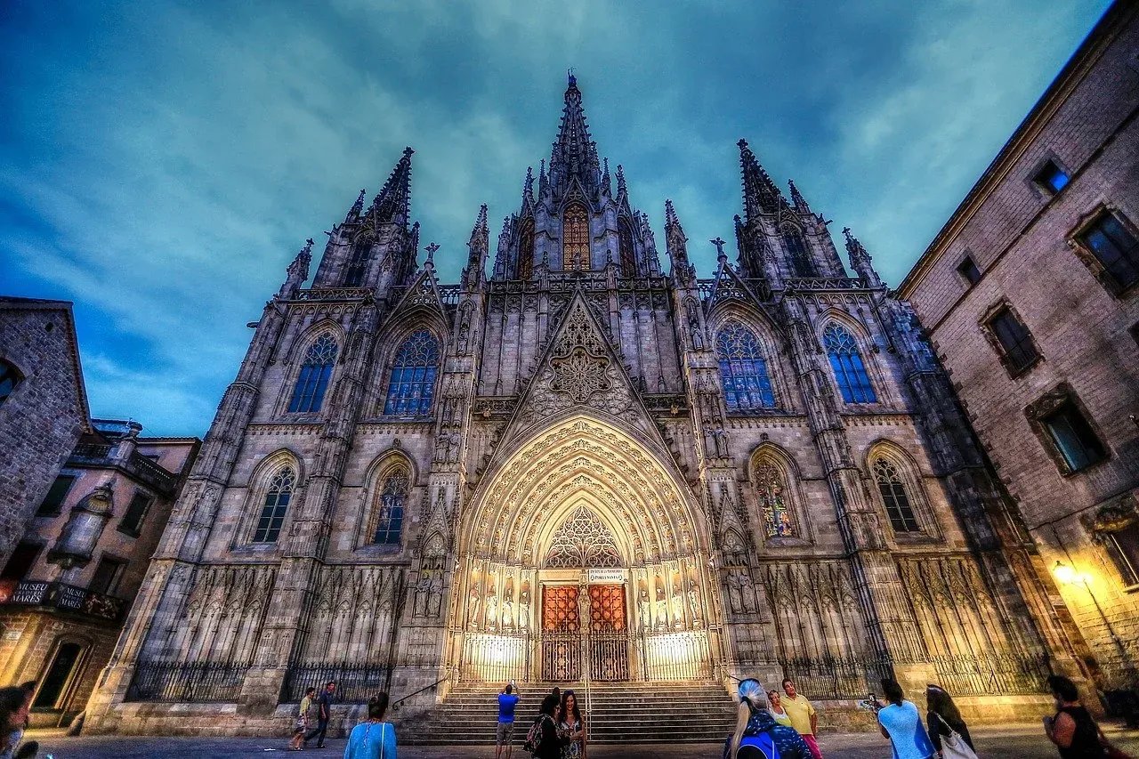 Catedral de Barcelona al atardecer, turistas admirando la arquitectura gótica.