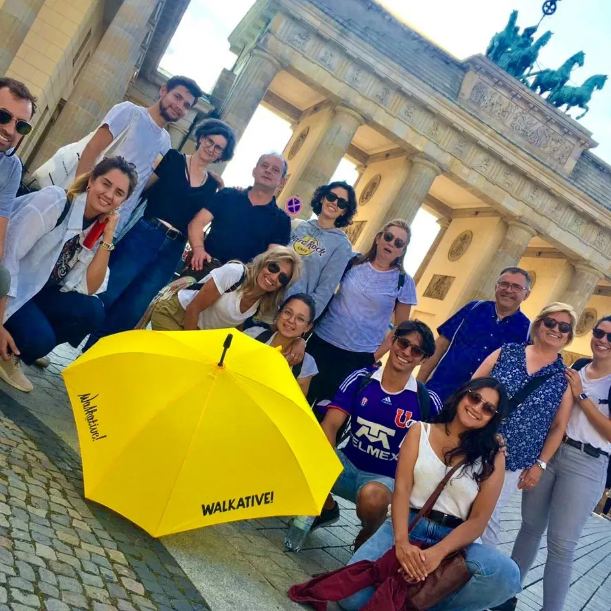 Happy tourists on a WALKATIVE! tour in front of Berlin's Brandenburg Gate.