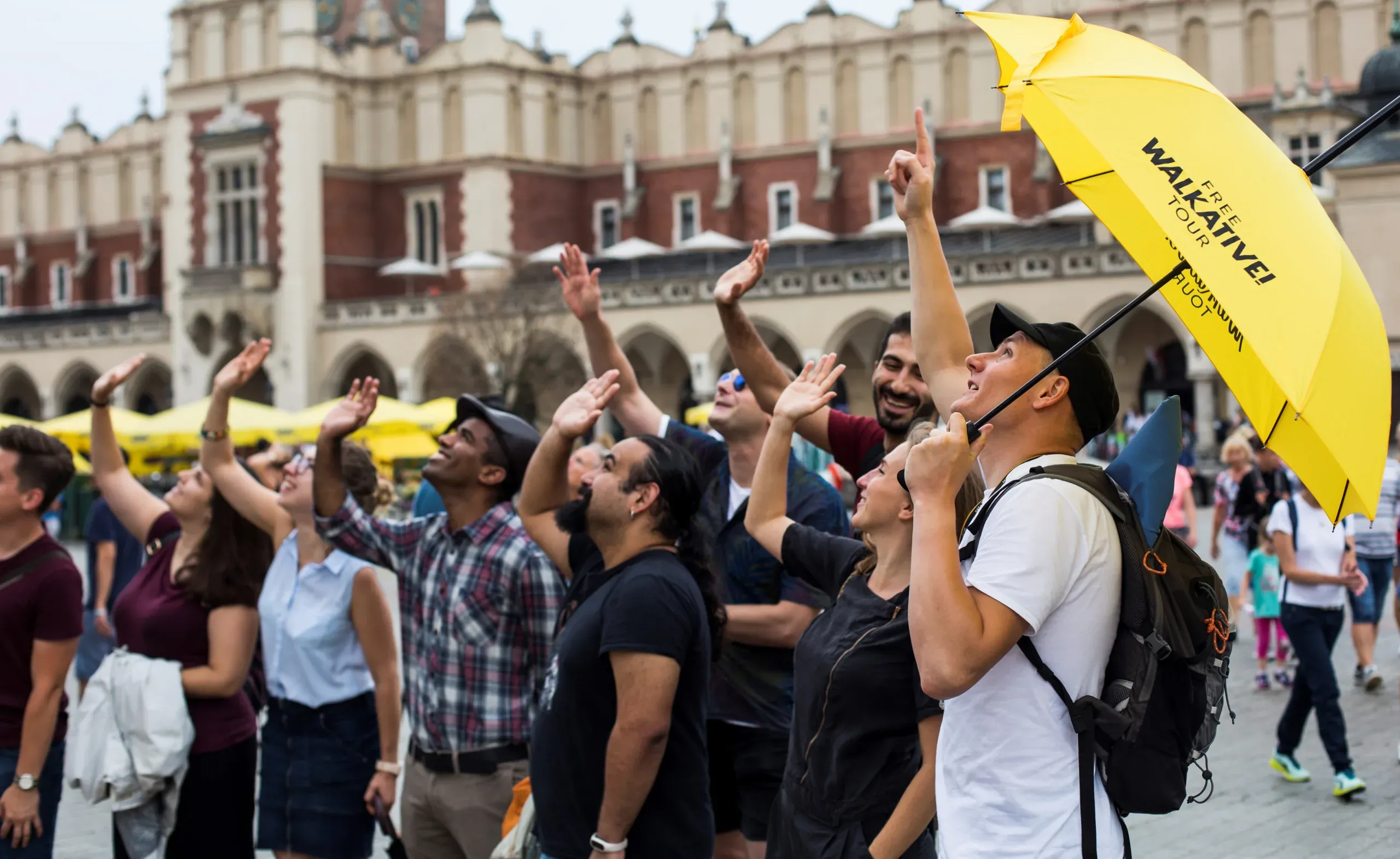 Un guía de Walkative! Free Tour conduce a un grupo de turistas en la Plaza Mayor de Cracovia.
