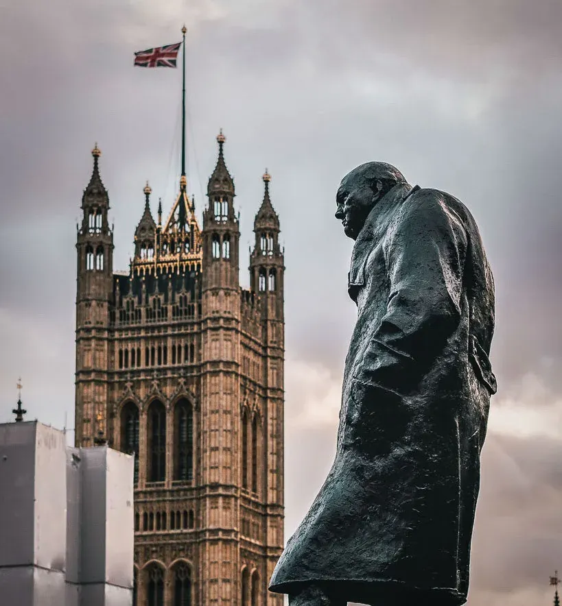 Statue von Winston Churchill mit dem Palace of Westminster im Hintergrund in London.