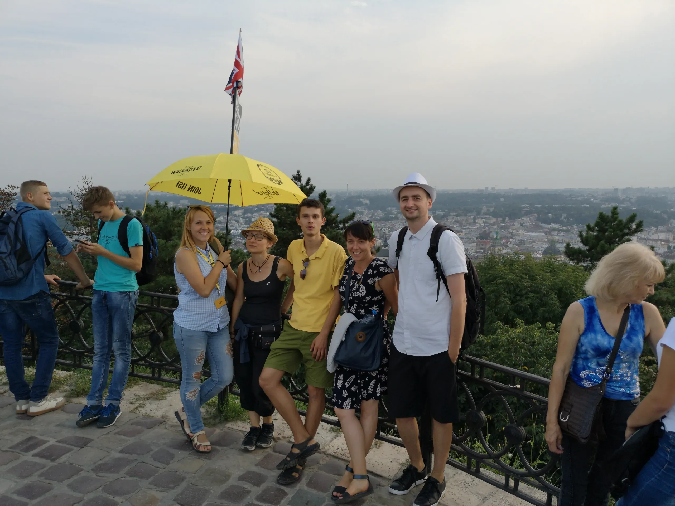 Grupa turystów na pieszej wycieczce po Lwowie na Ukrainie, podziwiająca panoramiczny widok na miasto.
