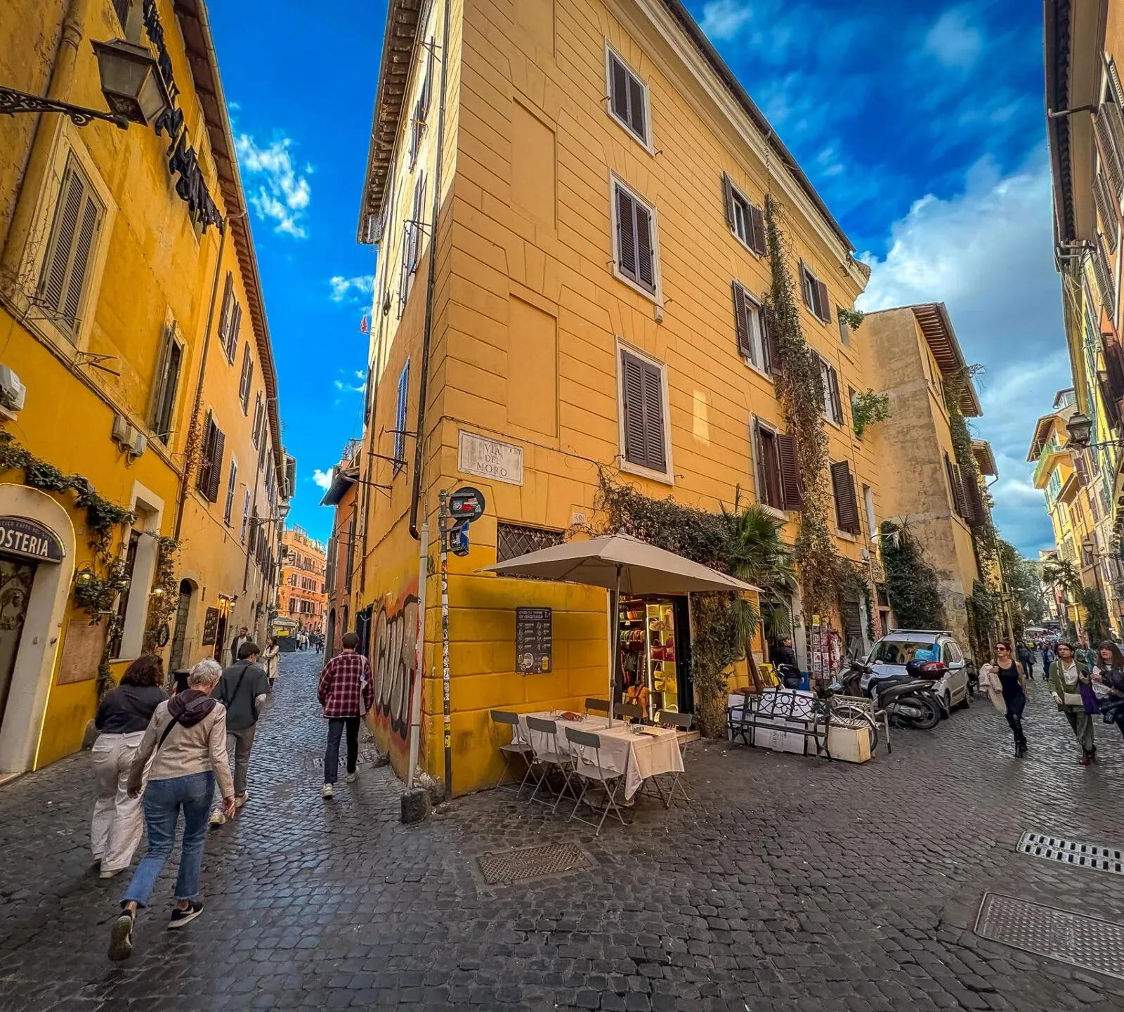 Touristen erkunden die charmanten Kopfsteinpflasterstraßen von Trastevere, Rom.