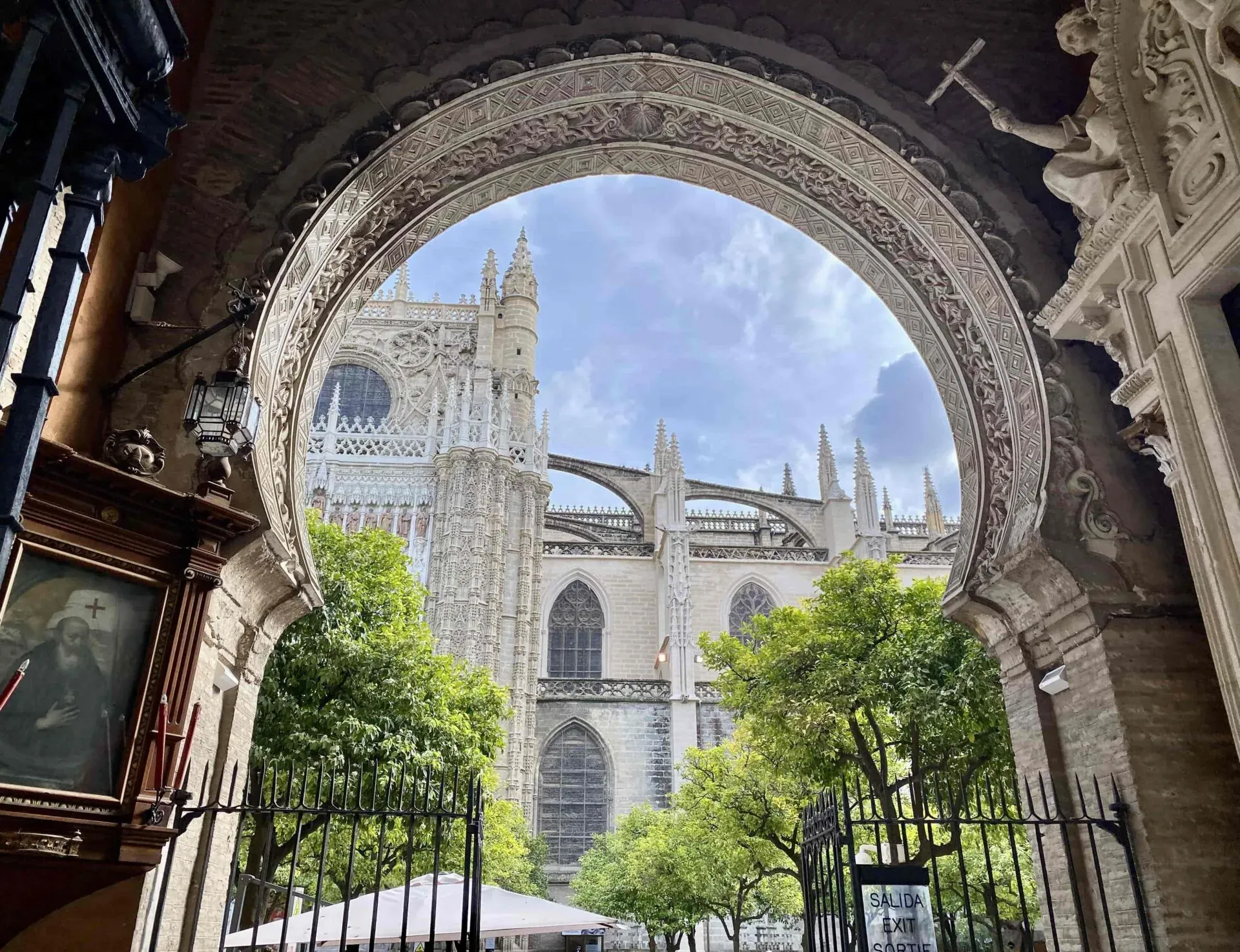 Atemberaubende Aussicht auf die Kathedrale von Sevilla durch einen verzierten Torbogen.