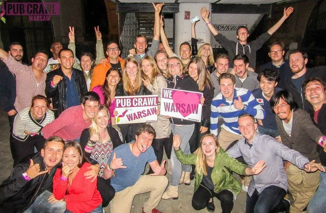 Eine große Gruppe fröhlicher Touristen auf einem Kneipenbummel in Warschau, Polen.